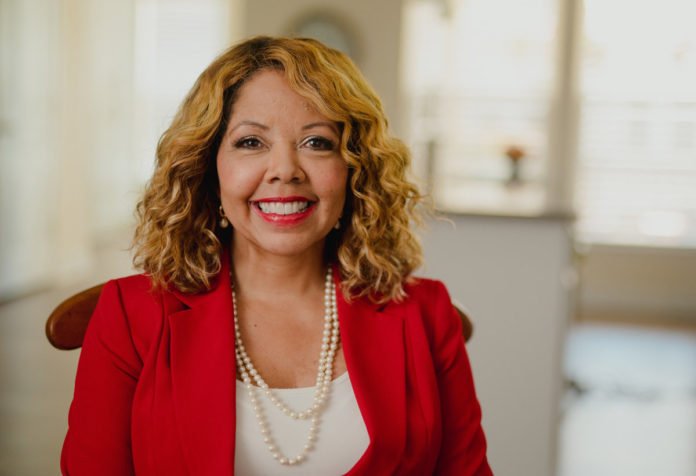 Lucy McBath in a red blazer smiling.